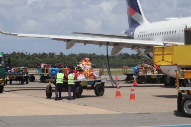 Personel havaalanında ticari kargo uçağı yüklüyor.