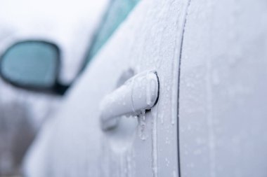 Araba kaplamalı. Donmuş araba. Kış sürücüsü. - Evet. Buz gibi desenler, buz saçakları ve kış mevsiminde kar ile ön camdan buzları kazıyarak. .