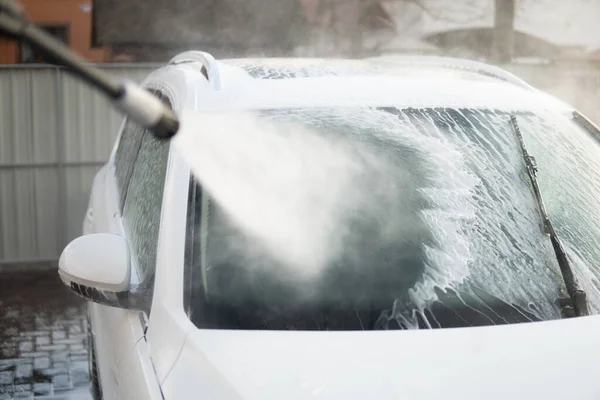 Ручная автомойка с белым мылом, пена на корпусе. — стоковое фото