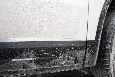 Elle oto yıkama dışarıda. Kapatın. Sabunla yıkıyorum. Elle yıkama, beyaz sabunla, gövdede köpük. Kapatın. Sabunla yıkıyorum. Yüksek Basınçlı Suyu Kullanarak Araba Temizleme.