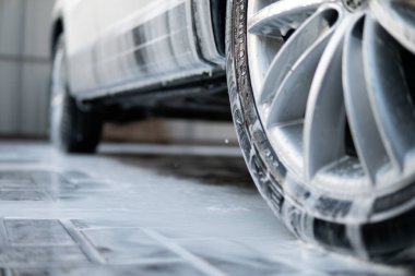 Elle yıkama, beyaz sabunla, gövdede köpük. Yüksek Basınçlı Su. Kapatın. Elle oto yıkama dışarıda. Araba Temizleme Sabunla Yıkama.