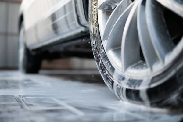 Близько. Ручна мийка на вулиці. Очищення автомобіля за допомогою мила. Вода високого тиску . — стокове фото