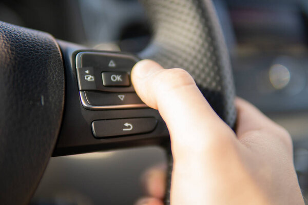 Driving car in traffic jam at urban city. Hand women holding steering wheel driving in traffic rush hour after finish work.