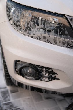 Yıkama sabunla yıkama. Yüksek Basınçlı Su. Kapatın. Elle oto yıkama dışarıda. Elle yıkama, beyaz sabunla, gövdede köpük. Dikey çekim