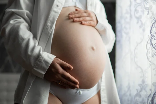 彼女の腹は手で 妊娠中の女の子に触れる妊娠中の女性のイメージ 背景妊娠9ヶ月の腹 お腹を抱えている妊婦さんは — ストック写真