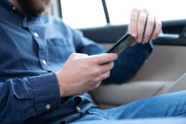 Boş ekran modeli. Şatonun arka planında cep telefonu kullanan bir adam. Bulanık Hipster mesajında akıllı telefon ya da teknoloji üzerinde erkek eli aleti tutuyor.,