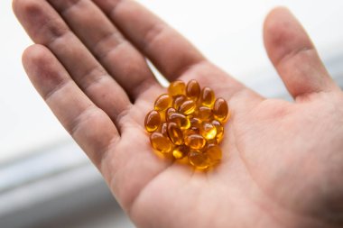 Yağ dolu kapsülleri kapatın: balık yağı, omega 3, omega 6, omega 9, A vitamini, D vitamini, D3 vitamini, kaşıklı E vitamini
