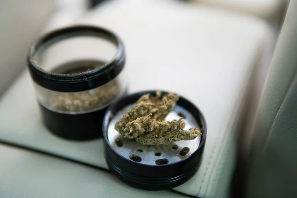 Cannabis Articulación Molinillo Paquete Hierba Sobre Fondo Coche Cerca Flores —  Fotos de Stock