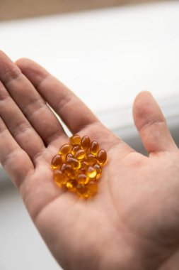 Yağ dolu kapsülleri kapatın: balık yağı, omega 3, omega 6, omega 9, A vitamini, D vitamini, D3 vitamini, kaşıklı E vitamini