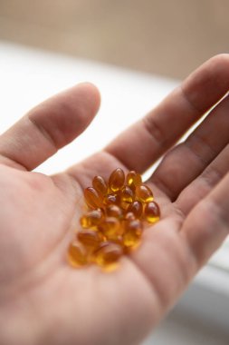 Beyaz üzerine dökülmüş D vitamini şişesinin temiz fotoğrafı.