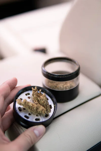 Flowers of cannabis. grinder and shredded cannabis in grinder joint and a packet of weed —  Fotos de Stock