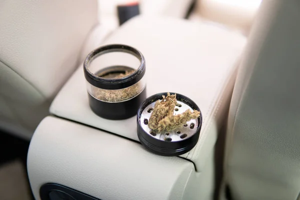 Cannabis in grinder joint and a packet of weed on a car background close up —  Fotos de Stock