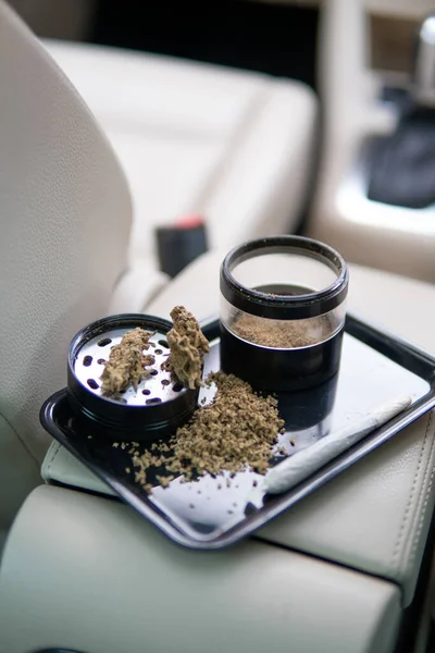 Πακέτο ζιζανίων σε ένα αυτοκίνητο φόντο κοντά μπουμπούκια μαριχουάνας λουλούδια — Φωτογραφία Αρχείου