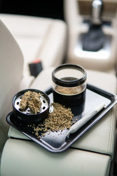 Cannabis conjunta e um pacote de ervas daninhas em um fundo de carro fechar maconha — Fotografia de Stock