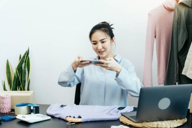 Asyalı girişimciler müşterilerle sohbet ediyor ve ürünlerinin resimlerini çekiyorlar..