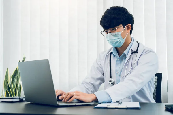 Doctor Estaba Sentado Oficina Trabajando Una Computadora Portátil Mientras Llevaba —  Fotos de Stock