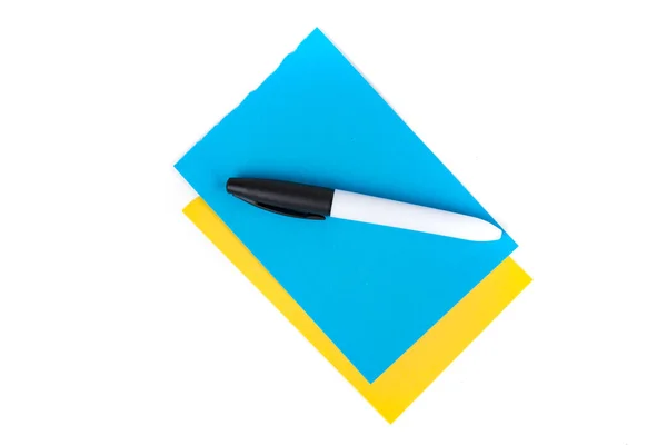 白の上に隔離された空白の青と黄色の層状ノートパッドページ上の永久的な黒いマーカー トップダウンビュー — ストック写真