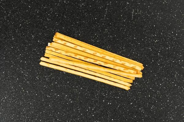 Gele Maïs Snack Sticks Zijaanzicht Een Zwarte Snijplank — Stockfoto