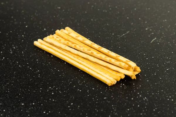 Yellow Corn Snack Sticks Top View Black Cutting Board — Stock Photo, Image
