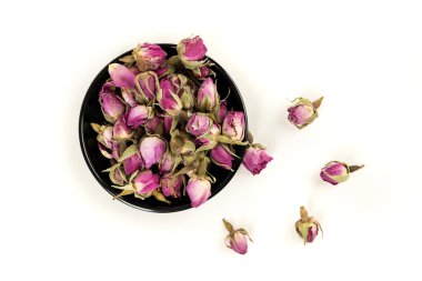 Kurumuş pembe gül tomurcukları siyah bir kasede.