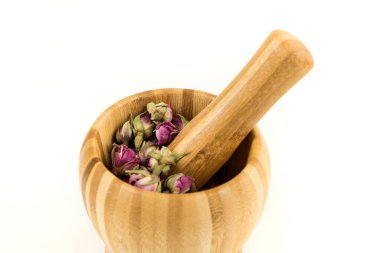 Kurumuş pembe gül tomurcuklarını ahşap bir havan ve tokmakla kapatın.