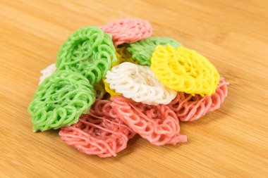 Beyaz üzerine izole edilmiş kesme tahtasındaki çok renkli tapyoka krakerleri.