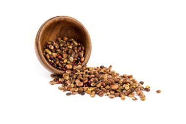 Kurutulmuş sumac üzümleri küçük bir ahşap kaseden beyaz açılı manzaraya dökülüyor.