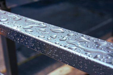 Çelik korkuluklara çiy damlıyor.