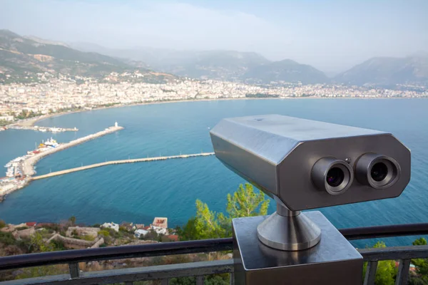 City paid binoculars on the observation deck in Alanya Turkey. Beautiful view of the city near the sea in Turkey on a sunny day.