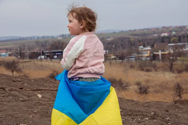Ukrayna bayraklı güzel bir kız çocuğu Ukrayna 'nın bir şehrinde bir gölün ve şehrin arka planında. Ukrayna bayrağıyla vatansever bir kızın portresi..