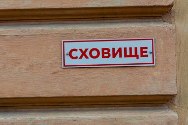 A plate on the wall of a house with the inscription SHELTER in a Ukrainian city. The war between Russia and Ukraine, grief, a sign of a bomb shelter for the townspeople.
