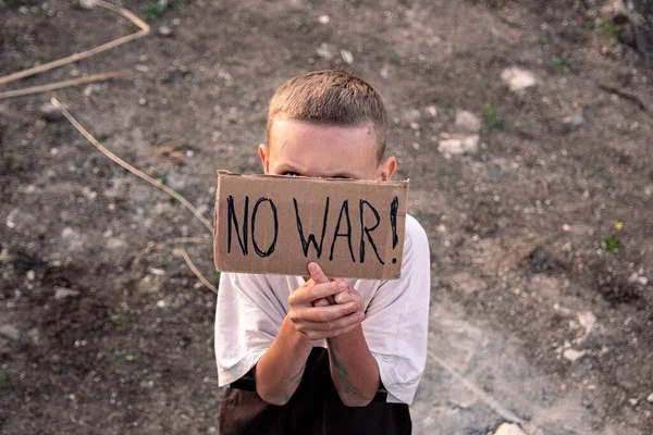 Pojke Med Ett Smutsigt Ansikte Och Sorgsna Ögon Håller Affisch — Stockfoto