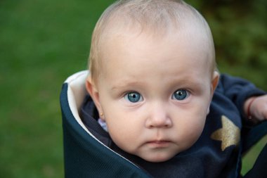 Güzel bir kızın portresi. Bebek güzel mavi gözleriyle kameraya bakıyor. Mavi elbiseli küçük bir çocuk..