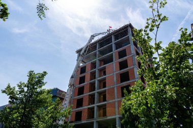 Türkiye, İstanbul 02.06.2022: Pompa, inşaat halindeki bir yüksek binanın çatısına beton taşıyor. İstanbul, Türkiye 'de bir ev inşa etme süreci.