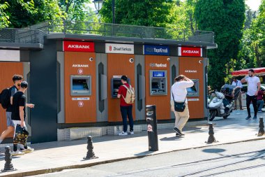 Türkiye, İstanbul 02.06.2022: Metropolün işlek bir caddesindeki çeşitli bankaların ATM 'leri. İnsanlar para çekip sokağın aşağısında bir yere gidiyorlar..