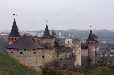 Ukrayna 'nın Podolsky şehrindeki antik taş kale. Bulutlu bir günde antik bir kalenin mimari anıtının fotoğrafı. Ortaçağ kalesinde kuleler var..