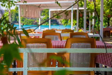 Restoranın yaz terasında masa ve sandalyeler. Türkiye 'nin tatil köyündeki restoranın basit plastik mobilyaları.