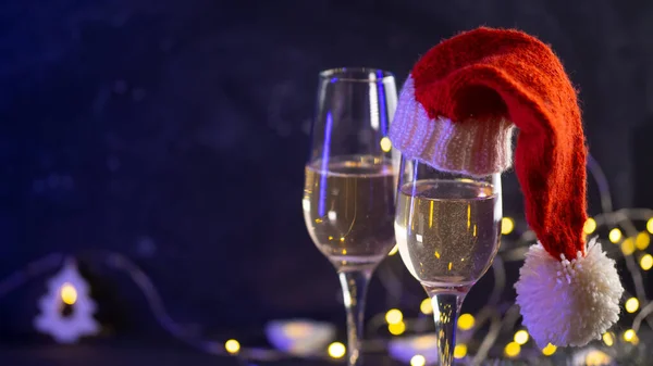 Dvě Sklenky Šampaňského Santově Klobouku Vánoční Věnce Noc Pozadí Kopírovat — Stock fotografie
