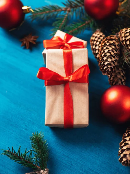 Két Ajándékdoboz Egy Kék Asztalon Egy Karácsonyfa Ágai Tobozokkal Piros — Stock Fotó
