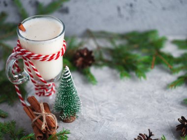 Noel içkisi, ağaç dalları olan ahşap masada yumurtalı nog.