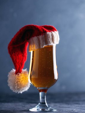 Noel ışığı, bardakta bira ve arka planda Noel Baba şapkası.