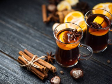 Geleneksel kış ve Noel sıcak içeceği ahşap bir masada sıcak şarap. Tarçın, anason, mandalina