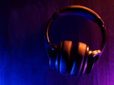 Kablosuz, modaya uygun kulaklıklar. Arka planda koyu bir fon var.