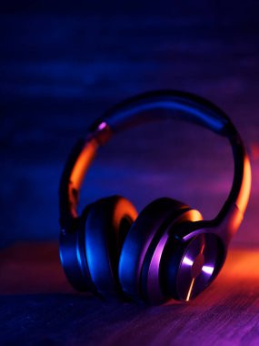 Kablosuz, modaya uygun kulaklıklar. Arka planda koyu bir fon var.