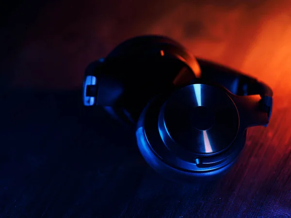 バックライト付きの暗い背景に無線スタイリッシュなヘッドフォンをオーバーヘッド — ストック写真