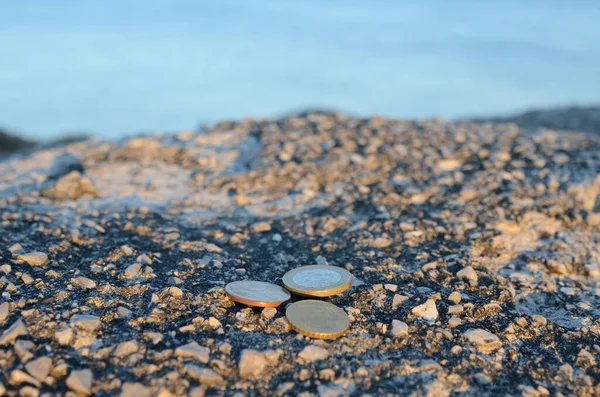 Mavi denizin kaya maliyetinde sikkeler