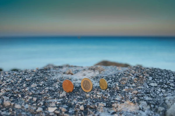 Mavi denizin kaya maliyetinde sikkeler
