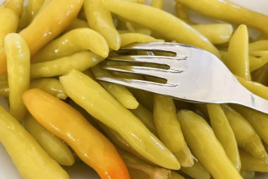 Beyaz bir tabakta hazır biber turşusu.