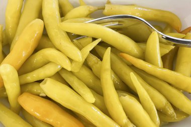 Beyaz bir tabakta hazır biber turşusu.