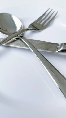 Beyaz tabakta kaşık, çatal, bıçak